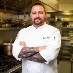 FLUX.2 [dev] — A tattooed chef in a white coat, arms crossed, con