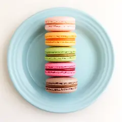FLUX.2 [dev] — A stack of colorful macarons on a pastel blue plat