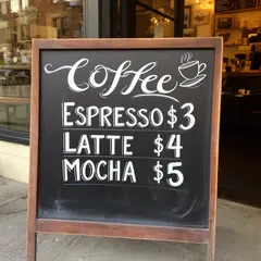 FLUX.2 [dev] — A hand-lettered chalkboard menu outside a coffee s