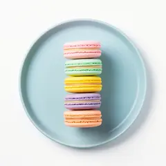 FLUX.2 [flex] — A stack of colorful macarons on a pastel blue plat