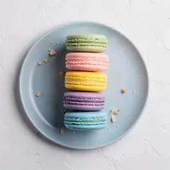 FLUX.2 [max] — A stack of colorful macarons on a pastel blue plat