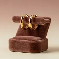 FLUX.2 [max] — A pair of gold hoop earrings on a velvet jewelry d