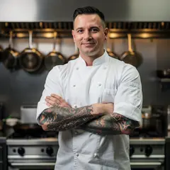 FLUX.2 [pro] — A tattooed chef in a white coat, arms crossed, con