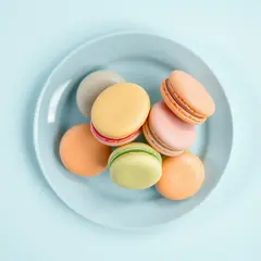 FLUX.1 [schnell] — A stack of colorful macarons on a pastel blue plat
