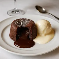 GPT Image 1 Mini — A dripping chocolate lava cake cut open on a white
