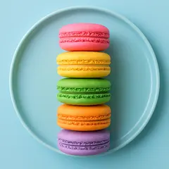 GPT Image 1 Mini — A stack of colorful macarons on a pastel blue plat
