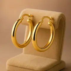 GPT Image 1 Mini — A pair of gold hoop earrings on a velvet jewelry d