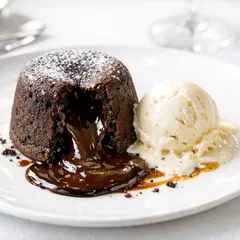 GPT Image 1.5 — A dripping chocolate lava cake cut open on a white