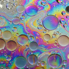 Grok Imagine — A macro photograph of oil droplets on water, iride