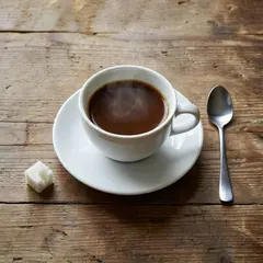 Grok Imagine — A cup of coffee on a saucer, with a spoon to the r