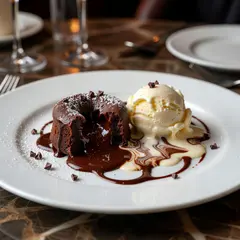 Grok Imagine — A dripping chocolate lava cake cut open on a white