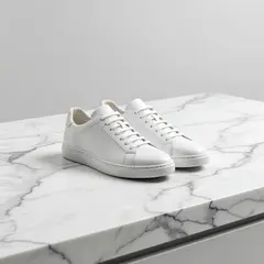 Grok Imagine — A pair of white leather sneakers on a marble count