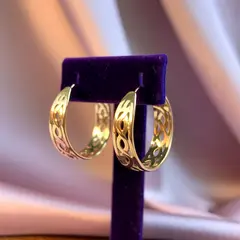 Ideogram V3 Turbo — A pair of gold hoop earrings on a velvet jewelry d