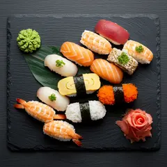 Imagen 3 — A perfectly plated sushi omakase on a black slate 