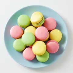 Imagen 3 — A stack of colorful macarons on a pastel blue plat
