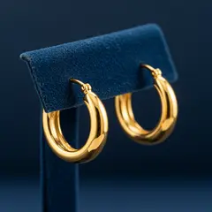 Imagen 3 — A pair of gold hoop earrings on a velvet jewelry d