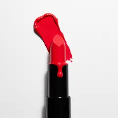 Imagen 3 — A tube of red lipstick standing upright, melting s
