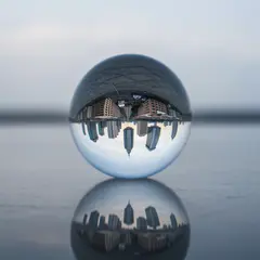 Imagen 4 Fast — A glass sphere refracting a distorted cityscape, s