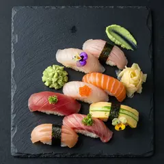 Imagen 4 Fast — A perfectly plated sushi omakase on a black slate 