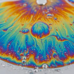 Imagen 4 — A macro photograph of oil droplets on water, iride