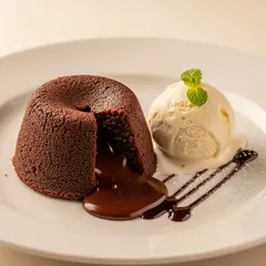 Imagen 4 — A dripping chocolate lava cake cut open on a white