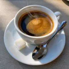 ImagineArt 1.5 — A cup of coffee on a saucer, with a spoon to the r