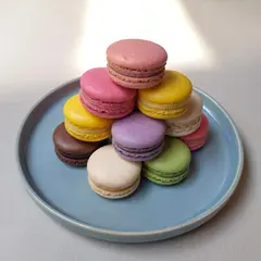 ImagineArt 1.5 — A stack of colorful macarons on a pastel blue plat