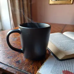 ImagineArt 1.5 — A matte black coffee mug with steam rising, placed