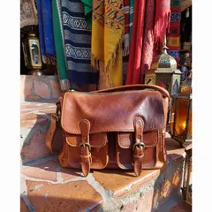 ImagineArt 1.5 — A leather messenger bag on a sun-dappled step in a