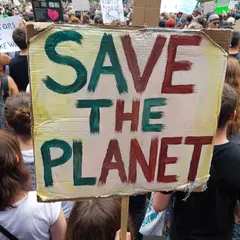 ImagineArt 1.5 — A protest sign held up in a crowd reading SAVE THE