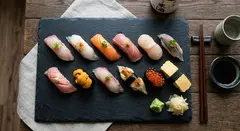 Gemini 3.1 Flash Image — A perfectly plated sushi omakase on a black slate 