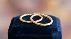 Gemini 3.1 Flash Image — A pair of gold hoop earrings on a velvet jewelry d