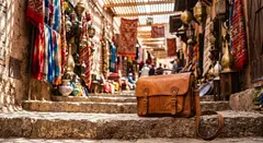 Gemini 3.1 Flash Image — A leather messenger bag on a sun-dappled step in a