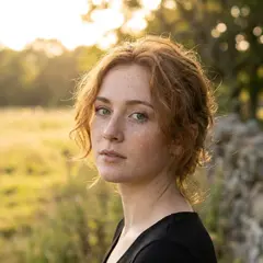 Gemini 3 Pro Image — A young woman with freckles and green eyes, golden