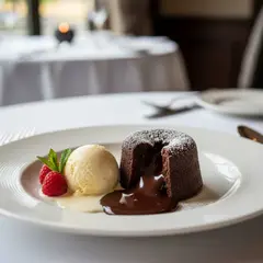 Gemini 2.5 Flash Image — A dripping chocolate lava cake cut open on a white