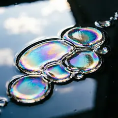 Qwen Image 2.0 — A macro photograph of oil droplets on water, iride