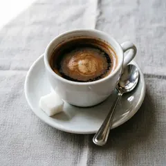 Qwen Image 2.0 — A cup of coffee on a saucer, with a spoon to the r