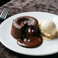 Qwen Image 2.0 — A dripping chocolate lava cake cut open on a white