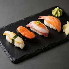 Qwen Image — A perfectly plated sushi omakase on a black slate 