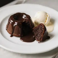 Qwen Image — A dripping chocolate lava cake cut open on a white