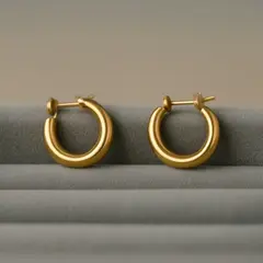Qwen Image — A pair of gold hoop earrings on a velvet jewelry d