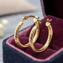 Recraft V3 — A pair of gold hoop earrings on a velvet jewelry d
