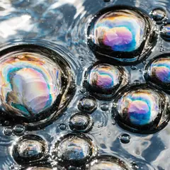 Recraft V4 — A macro photograph of oil droplets on water, iride
