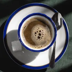 Recraft V4 — A cup of coffee on a saucer, with a spoon to the r