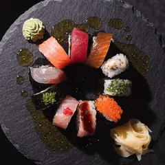 Recraft V4 — A perfectly plated sushi omakase on a black slate 