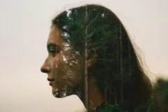 Reve v1.0 — A double exposure photograph combining a forest wi