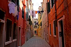 Reve v1.0 — A narrow cobblestone alley in Venice with colorful