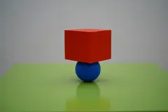 Reve v1.0 — A red cube on top of a blue sphere, both sitting o