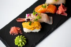 Reve v1.0 — A perfectly plated sushi omakase on a black slate 