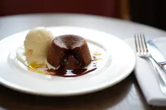 Reve v1.0 — A dripping chocolate lava cake cut open on a white